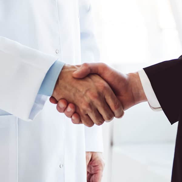 endodontist shaking hands with business